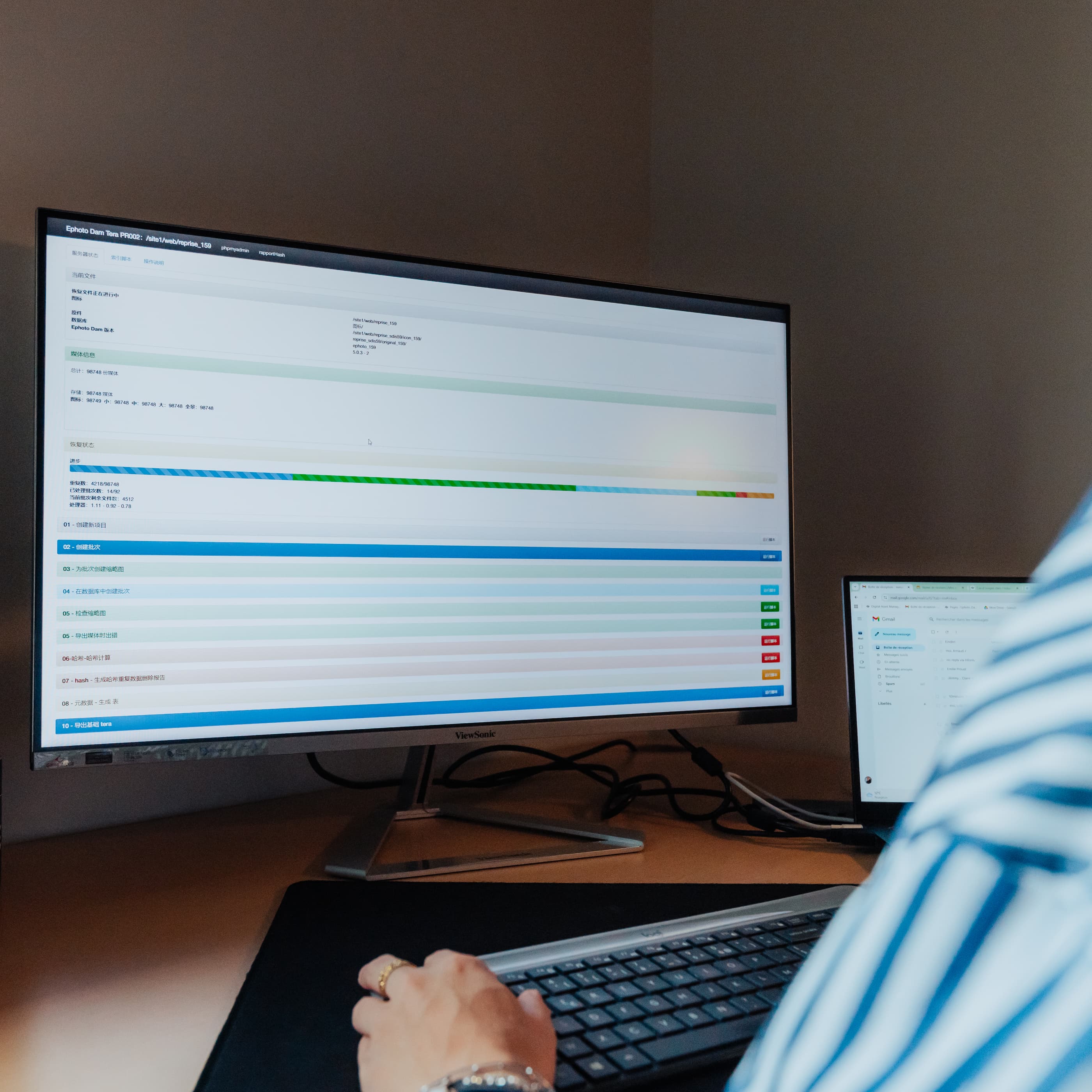 桌子上的电脑，配有键盘、鼠标、台灯和硬盘。