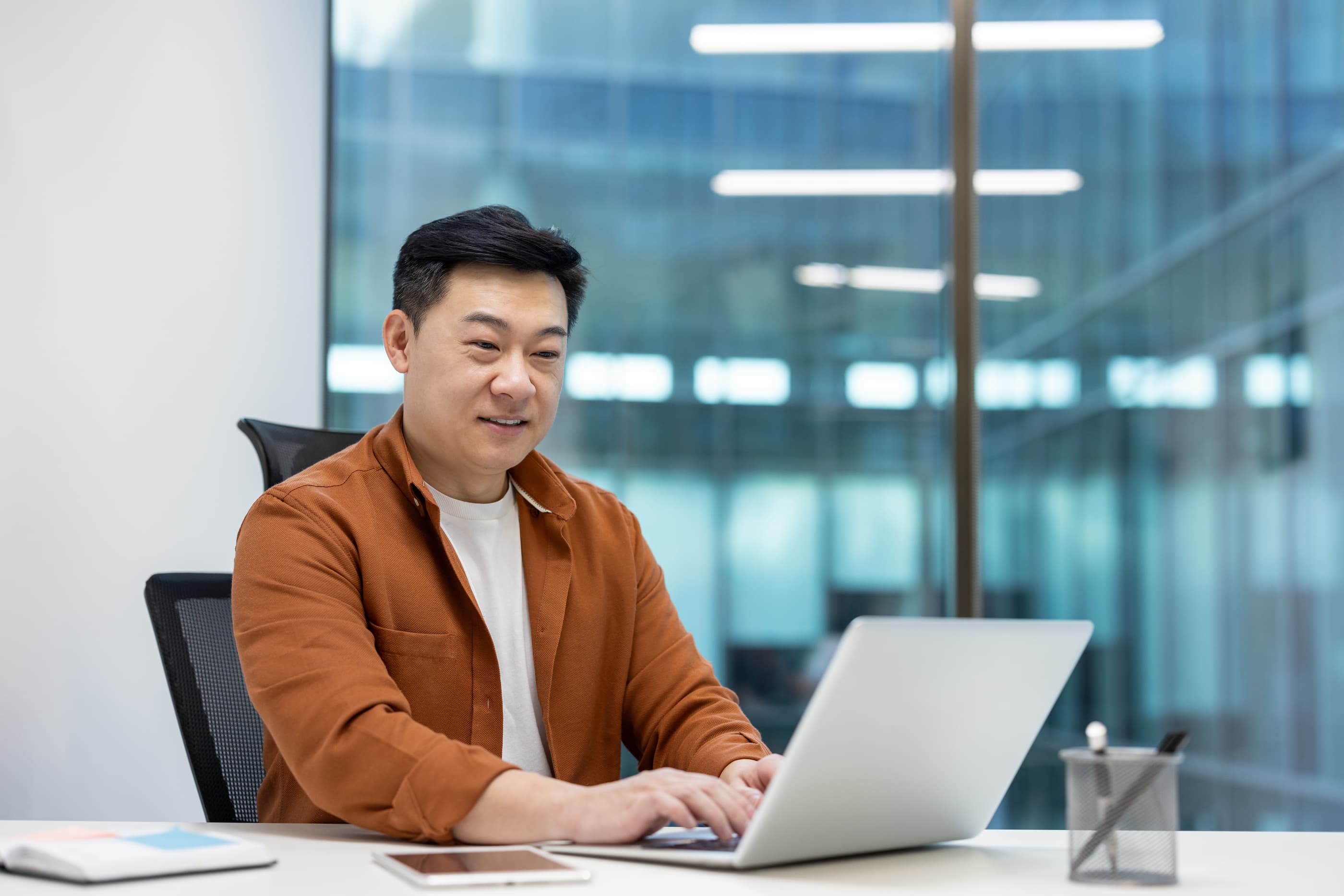 戴眼镜的大胡子在电脑前工作,展示 Ephoto Dam 先进的数字资产管理功能。