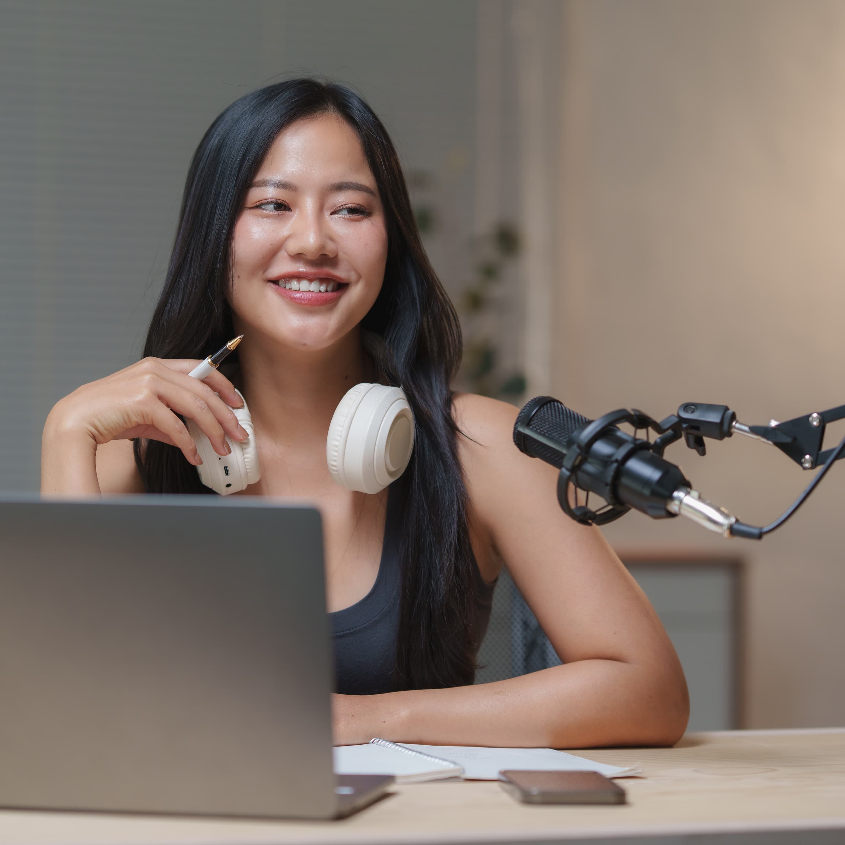 在 Ephoto Dam 照片库解决方案的专业视频工作室中，坐着的妇女对着拍摄她的摄像机微笑。