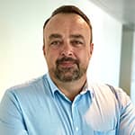 身着蓝色衬衫的男子肖像照。