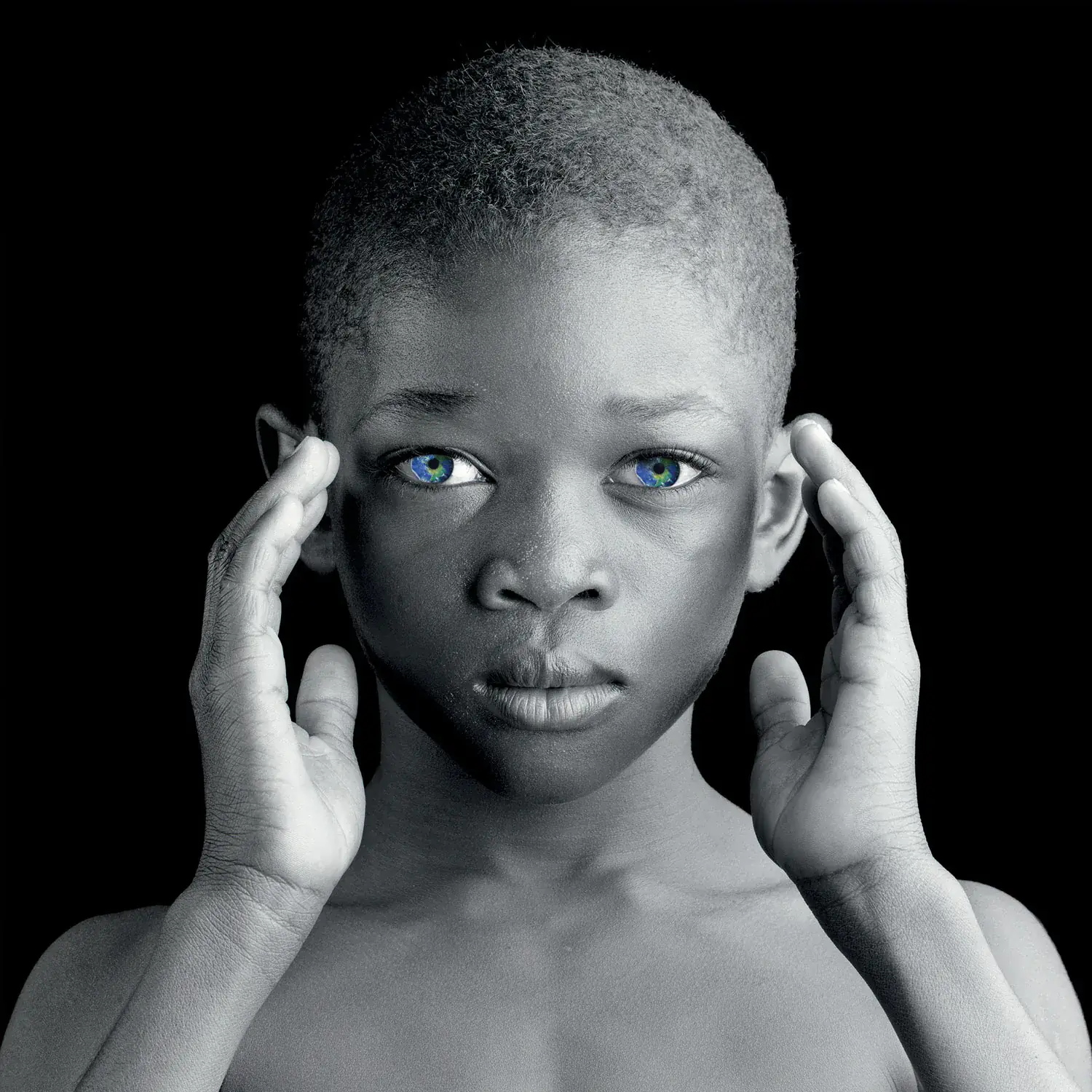 一个孩子的黑白肖像,双手托着脸边。